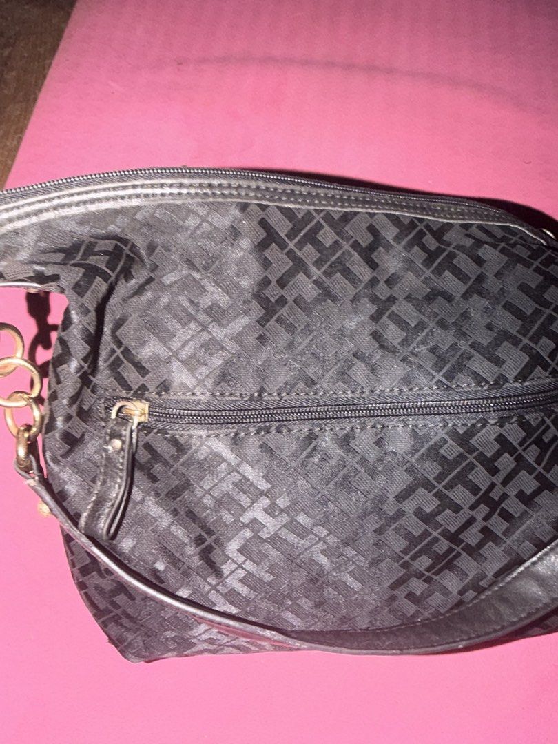 Tommy Hilfiger Monogram Shoulder Bag Black (Category: Shoulder Bags) located in Cavite. Submitted by declutterringggggg (Listing ID 1466829301, Image 3). Description: Tommy Hilfiger shoulder bag in black monogram fabric. Features chunky gold-tone ring accents on the straps and a branded front button closure. Roomy interior with a secure top zip opening. Shows some wear on the hardware finish and metallic logo badge. Casual style for daily use..