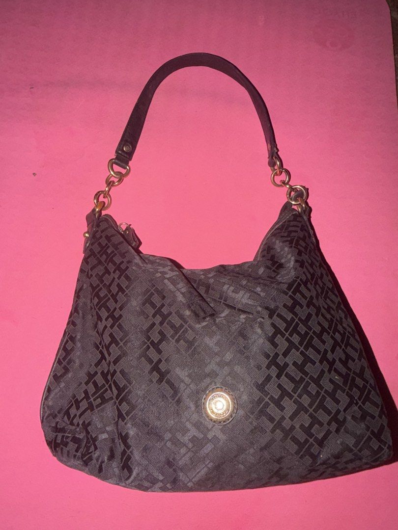 Tommy Hilfiger Monogram Shoulder Bag Black (Category: Shoulder Bags) located in Cavite. Submitted by declutterringggggg (Listing ID 1466829301, Image 1). Description: Tommy Hilfiger shoulder bag in black monogram fabric. Features chunky gold-tone ring accents on the straps and a branded front button closure. Roomy interior with a secure top zip opening. Shows some wear on the hardware finish and metallic logo badge. Casual style for daily use..