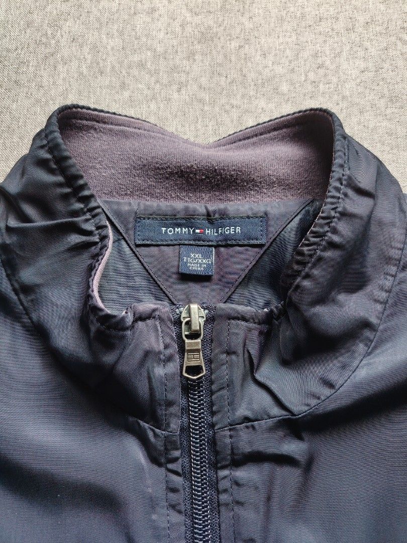 Tommy Hilfiger Navy Blue Zip Up Jacket (Category: Coats, Jackets and Outerwear) located in Taguig. Submitted by _theroom.ph (Listing ID 1466840902, Image 3). Description: - Brand: Tommy Hilfiger - Color: Navy Blue - Size: XXL - Design: Bold HILFIGER chest print & classic flag logo on left sleeve - Comfort: Fleece-lined stand-up collar, ribbed cuffs, and hem - Features: Full zip closure with custom hardware, two front welt pockets - Origin: Made i