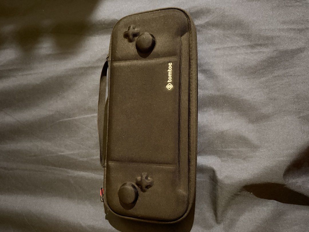 Tomtoc Hard Shell Carrying Case for Nintendo Switch (Category: Cases & Covers) located in Caloocan City. Submitted by cjbuendia21 (Listing ID 1466963697, Image 1). Description: - Authentic Tomtoc carrying case for Nintendo Switch in sleek black - Rugged exterior with a molded shell to protect your screen and thumbsticks - Soft interior lining to prevent scratches and keep your console pristine - Built-in storage flap securely holds multiple game 