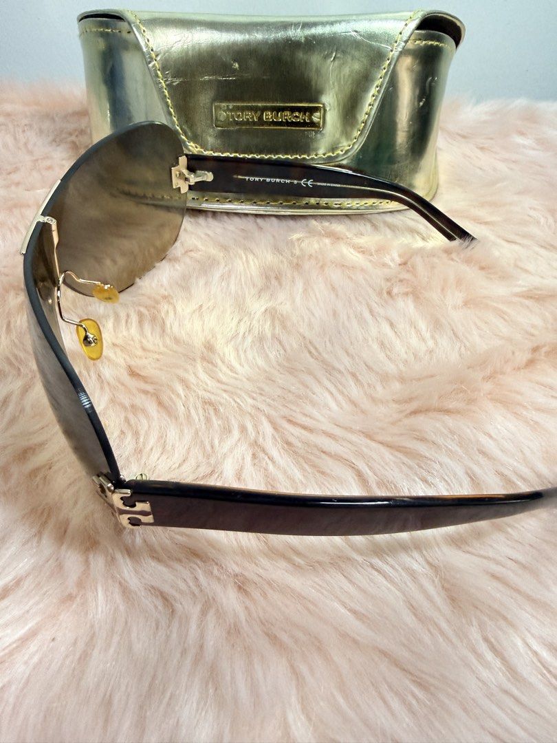 Tory Burch Shield Sunglasses with Gold Case (Category: Sunglasses & Eyewear) located in Quezon City. Submitted by shaberbree (Listing ID 1466908671, Image 2). Description: - Brand: Tory Burch - Style: Shield sunglasses with gradient brown tint - Frame: Dark tortoiseshell arms with gold Tory Burch logo hardware at hinges - Model No: TY6003 101/8 120 3N - Inclusion: Matching metallic gold hard case with embossed Tory Burch plaque - Condition: Well-
