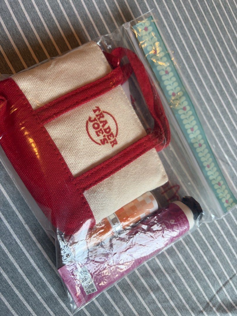 Trader Joe's Canvas Micro Tote Gift Set with Extras (Category: Tote Bags) located in Quezon City. Submitted by mmiyah27 (Listing ID 1466793100, Image 3). Description: - Brand new with tags (BNWT) Trader Joe's canvas micro tote bag with red trim, handles, and zipper closure (SKU 82352) - Includes a handy grocery bag tucked inside the tote - Bath & Body Works Twisted Peppermint shea butter hand cream (1 fl oz) - Clinique lipstick included - Beautif