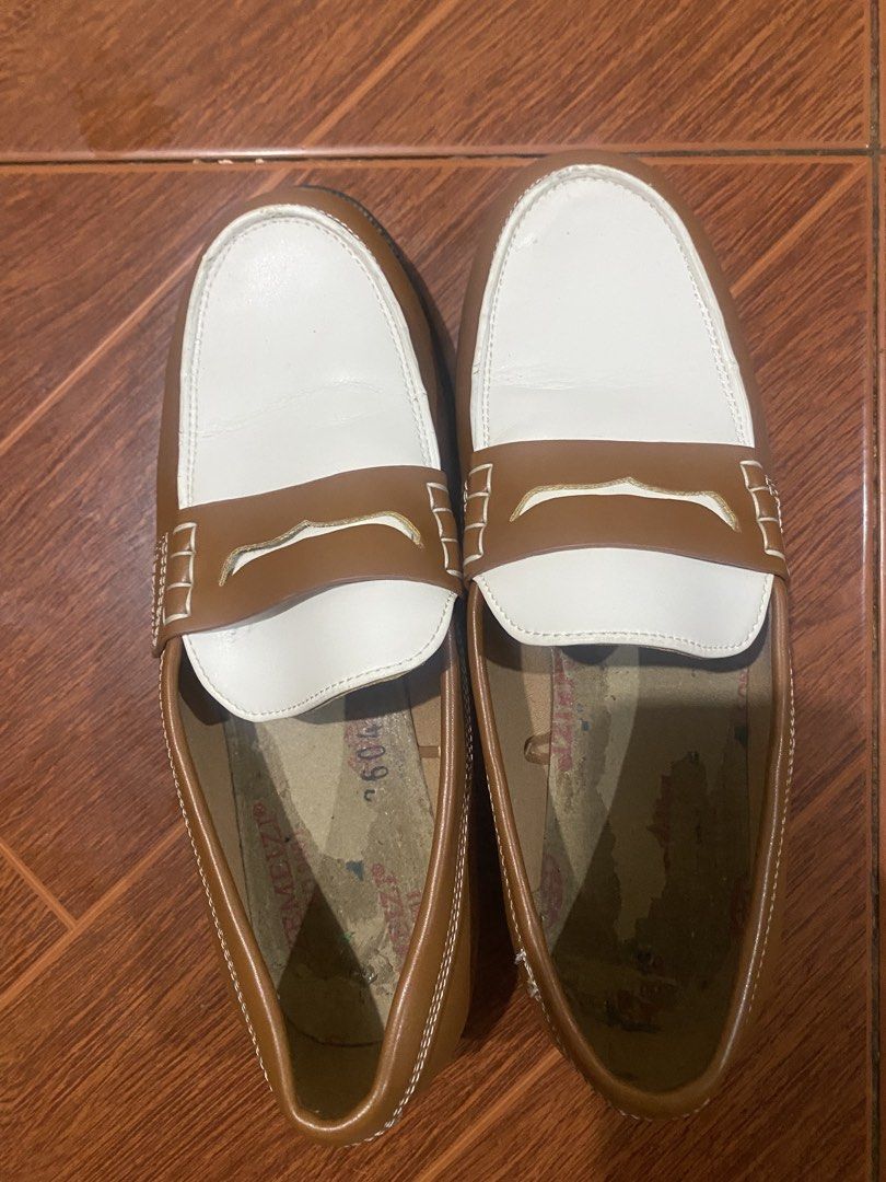 Two-tone brown and white penny loafers (Category: Casual Shoes) located in Manila. Submitted by trish.may1 (Listing ID 1466823036, Image 1). Description: - Style: Two-tone brown and white penny loafers (slip-on) - Design: White toe panels with brown leather accents and white contrast stitching - Heel: Black stacked heel - Soles: Sturdy outer soles with plenty of life left - Condition: Inner soles show wear and peeling on the lining.