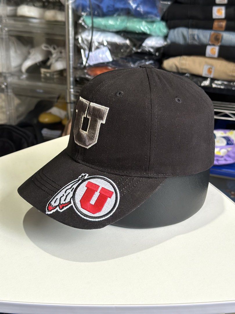 Utah Utes Captivating Headgear Black Cap (Category: Caps & Hats) located in Daet. Submitted by thrifthings2018 (Listing ID 1466859221, Image 3). Description: - Brand: Captivating Headgear - Team: Utah Utes - Color: Black - Material: 100% cotton - Design: Embroidered U logo on front and additional logo patch on the brim - Closure: Adjustable strap in the back for a custom fit - Origin: Made in Vietnam - Condition: Clean interior lining with proper