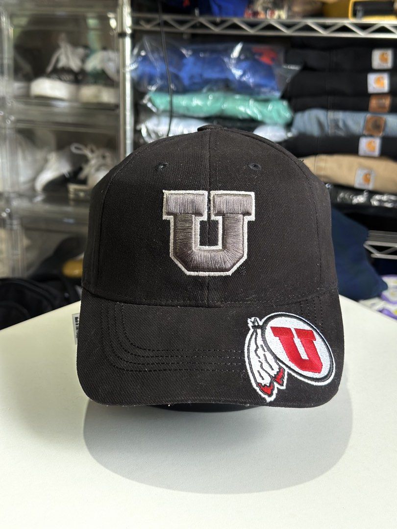 Utah Utes Captivating Headgear Black Cap (Category: Caps & Hats) located in Daet. Submitted by thrifthings2018 (Listing ID 1466859221, Image 2). Description: - Brand: Captivating Headgear - Team: Utah Utes - Color: Black - Material: 100% cotton - Design: Embroidered U logo on front and additional logo patch on the brim - Closure: Adjustable strap in the back for a custom fit - Origin: Made in Vietnam - Condition: Clean interior lining with proper