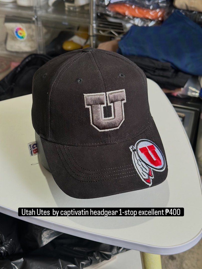 Utah Utes Captivating Headgear Black Cap (Category: Caps & Hats) located in Daet. Submitted by thrifthings2018 (Listing ID 1466859221, Image 1). Description: - Brand: Captivating Headgear - Team: Utah Utes - Color: Black - Material: 100% cotton - Design: Embroidered U logo on front and additional logo patch on the brim - Closure: Adjustable strap in the back for a custom fit - Origin: Made in Vietnam - Condition: Clean interior lining with proper
