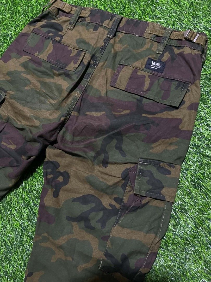 Vans Camo Cargo Pants Size 28 (Category: Jeans) located in Pangantucan. Submitted by calmwhale_cb83a8 (Listing ID 1466800642, Image 1). Description: - Brand: Vans - Style: Camo cargo pants with elastic ankle cuffs - Size: 28-29 - Made in India - Pattern: Classic woodland camouflage all over - Storage: Multiple utility pockets on sides and back - Details: Button closure, zipped fly, and woven Vans logo patch on back pocket - Interior: Clean lining