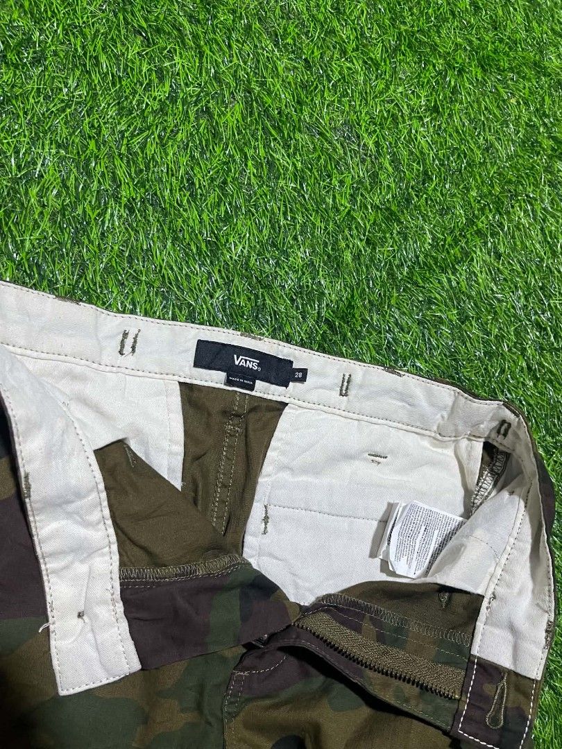 Vans Camo Cargo Pants Size 28 (Category: Jeans) located in Pangantucan. Submitted by calmwhale_cb83a8 (Listing ID 1466800642, Image 2). Description: - Brand: Vans - Style: Camo cargo pants with elastic ankle cuffs - Size: 28-29 - Made in India - Pattern: Classic woodland camouflage all over - Storage: Multiple utility pockets on sides and back - Details: Button closure, zipped fly, and woven Vans logo patch on back pocket - Interior: Clean lining