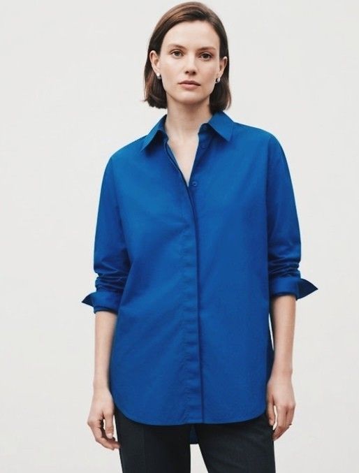 Vibrant Blue Button-Up Shirt with Pocket (Category: Blouses) located in Donsol. Submitted by saksthriftavenuebyluckymaria8 (Listing ID 1466947293, Image 1). Description: - Color: Bright blue - Style: Classic collar, button-down - Sleeves: Long sleeves with buttoned cuffs - Details: Single chest pocket on the right, curved hemline - Versatility: Great for layering or standalone casual and smart-casual outfits sz L chest 24in armhole 10in shoulder 