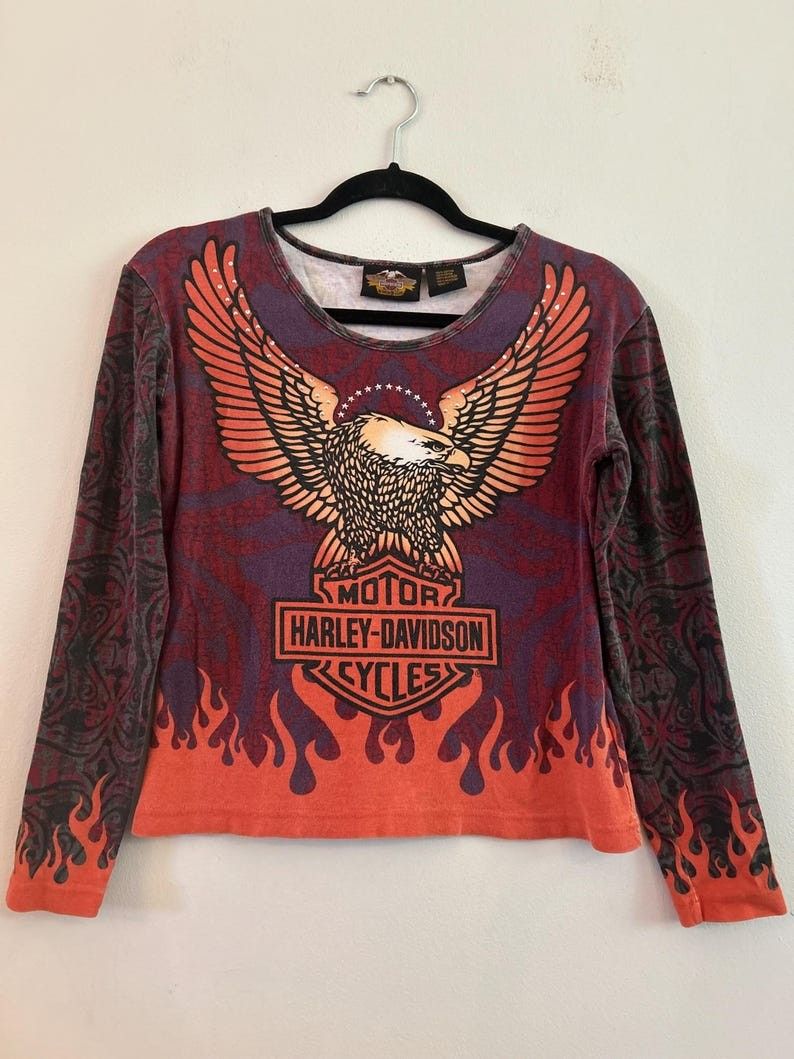 Vintage 00s Harley Davidson AOP Flame & Eagle Design* (Category: Longsleeves) located in Cabuyao City. Submitted by roronhilira (Listing ID 1466968450, Image 2). Description: Vintage 00s Harley Davidson AOP Flame & Eagle Design* Women Tops 2W size tag 23 pit to pit 26 length very good condition 1200 shipped DM 📥.
