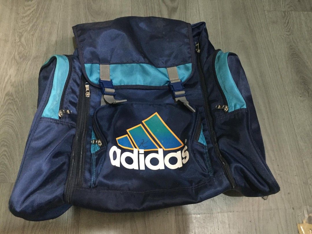 Vintage Blue and Teal Adidas Backpack (Category: Backpacks) located in General Santos City (Dadiangas). Submitted by loloikoh63127 (Listing ID 1466800177, Image 1). Description: - Dark blue Adidas backpack featuring vibrant teal accents and a large vintage logo on the front pocket - Comfortable padded tan back panel with stylish quilted diamond stitching - Multiple zippered compartments and side pockets to keep your essentials organized - Adjusta
