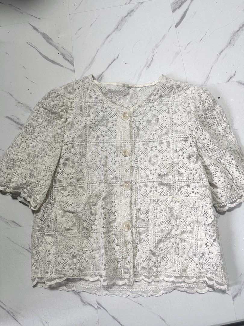 Vintage cotton Lace Button-Down blouse (Category: Blouses) located in Manila. Submitted by tipidfinds888 (Listing ID 1466854096, Image 1). Description: - Color: Cream - Design: Intricate crochet-style lace pattern throughout - Sleeves: Short puff sleeves with scalloped cuffs - Details: Front button closure with four round buttons and two lower front patch pockets - Hem & Neckline: Scalloped edges - Fit/Style: Sheer fabric, perfect for layering ov