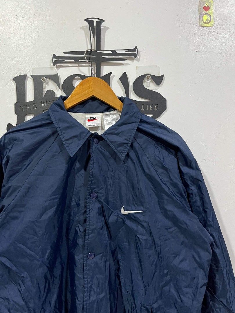 Vintage Nike Nylon Coach Jacket (Category: Coats, Jackets and Outerwear) located in Manila. Submitted by tristan12_13 (Listing ID 1466944706, Image 2). Description: - Nike Vintage Coach Jacket ( 1990s Tags) - Size Large on tag - Dimension: W- 24 L- 28 - Condition: Like New - No Flaws - Color: Navy Blue - Material: 100% Nylon - Features: Snap button closure, side pockets, elastic cuffs, and small embroidered white swoosh logo on chest - Condition: