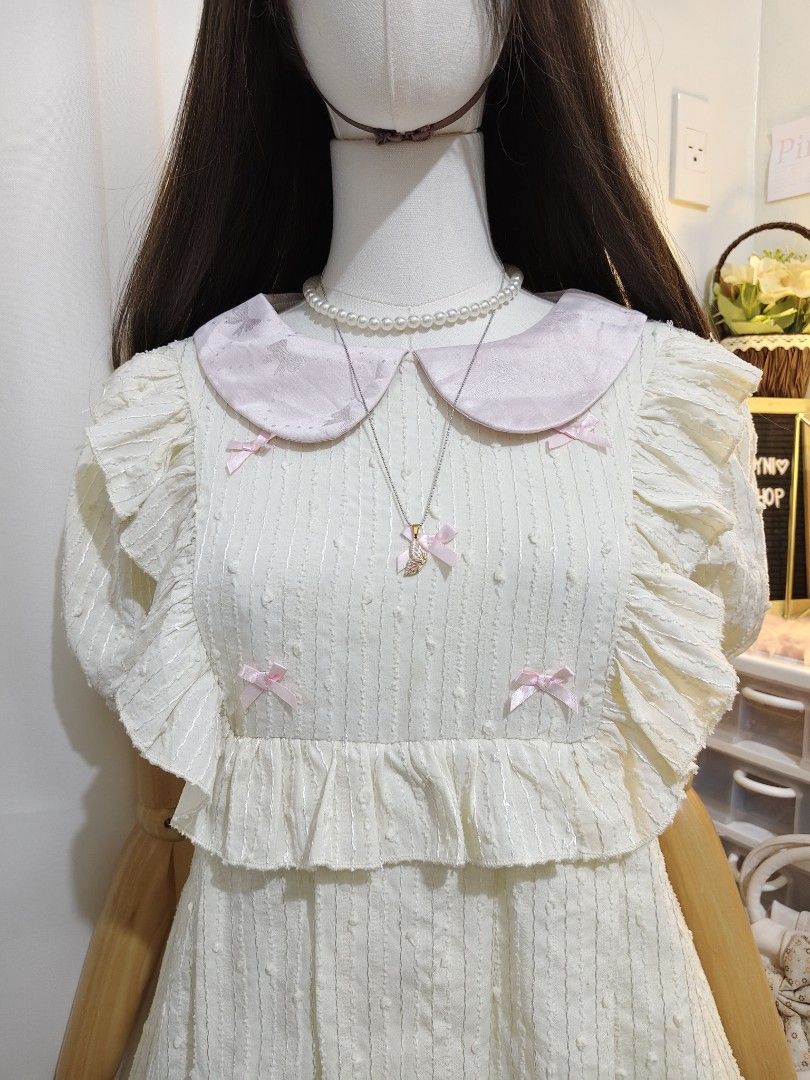 Vlovelan Pink Bow White Dress (Category: Dresses) located in Manila. Submitted by chynii_28 (Listing ID 1466865741, Image 2). Description: - Brand: Vlovelan - Color: White with pink collar and bow accents - Details: Ruffles and lace hem at the bottom - Measurements: Bust 36" | Waist 36" | Length 34" - Condition: Like new, no flaws found - Style: Cute, sweet, and feminine.
