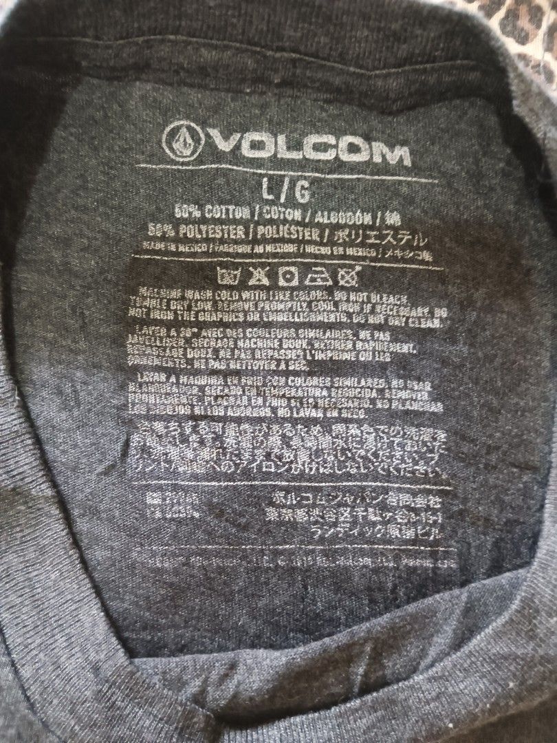 Volcom Heather Grey T-Shirt Size L (Category: Tshirts & Polo Shirts ) located in Davao. Submitted by jasondagam14678 (Listing ID 1466784483, Image 2). Description: - Brand: Volcom - Style: Crewneck t-shirt with bold white chest logo - Color: Dark heather grey - Size: Large - Material: 50% cotton, 50% polyester blend - Fit: Standard fit with tagless inner neck - Condition: Clean, excellent, and ready to wear.