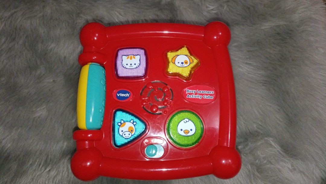 VTech Busy Learners Activity Cube 850 pesos (Category: Infant Playtime) located in Agdangan. Submitted by strawberryvanilla9 (Listing ID 1466828228, Image 1). Description: - Multi-sided VTech activity cube designed for toddlers - Features letter blocks, numbers, animals, shapes, and musical buttons - Includes sliding elements and a battery-operated interactive top panel - Designed with bright primary colors (red, yellow, blue, and green) - Great 