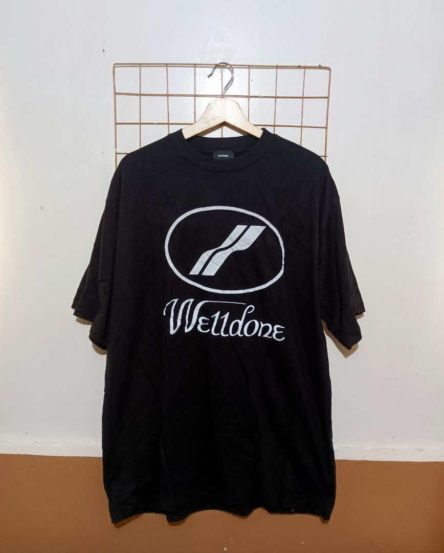 We11done Black Logo T-Shirt Size M (Category: Tshirts & Polo Shirts ) located in Davao. Submitted by jasondagam14678 (Listing ID 1466784696, Image 1). Description: - Brand: We11done - Color: Black - Size: Medium - Design: Large oval chest graphic logo with smaller cursive branding on the upper back - Details: Classic crew neck, short sleeves, woven inner collar tag, and interior care label - Material: Premium cotton - Condition: Excellent, well-m