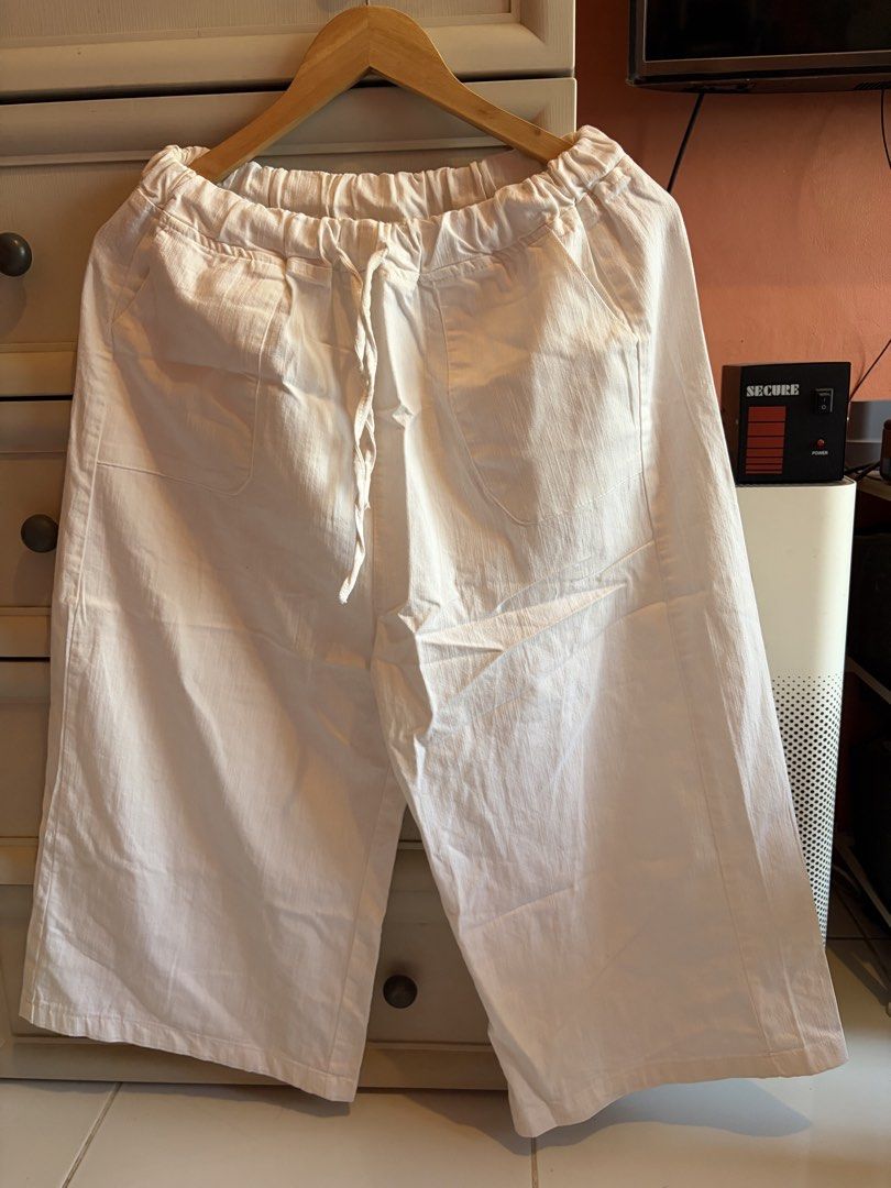 White drawstring wide leg crop pants trousers (Category: Jeans) located in Quezon City. Submitted by mmiyah27 (Listing ID 1466795024, Image 1). Description: - Color: White - Style: Casual cropped trousers with a wide, relaxed leg fit (hits around the calf) - Material: Lightweight and breathable fabric, perfect for warm weather - Waistband: Elastic with a matching center drawstring tie - Pockets: Two deep front patch pockets on the hips - Details: