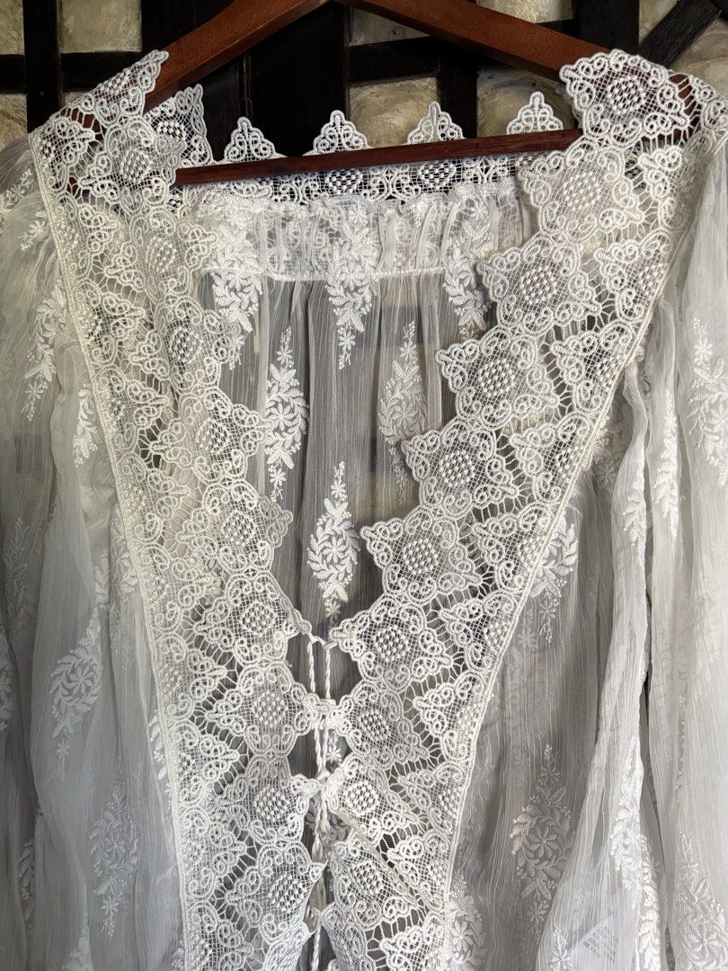 White Lace Trimmed Sheer Blouse (Category: Blouses) located in Batangas. Submitted by purple_and_orange (Listing ID 1460963711, Image 2). Description: - Sheer white blouse - V-neck with tie-up front - Long balloon sleeves - Intricate lace detailing on neckline and cuffs - Subtle embroidered pattern throughout fabric - Ideal for layering or a bohemian style.