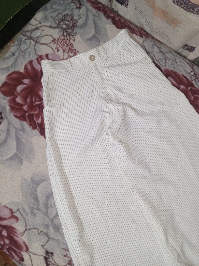 White pinstripe wide leg trousers with button closure (Category: Trousers) located in Baguio. Submitted by tyrontoler83676 (Listing ID 1466932902, Image 3). Description: ‎White Stripe baggy Pants ‎Length 40 inches ‎Waistline 30 inches ‎Leg opening 14 inches ‎Tight 15 inches - Color/Pattern: White with black vertical pinstripes - Fit: Wide leg, high waist style with belt loops and single front button closure - Pockets: Two practical side pockets -