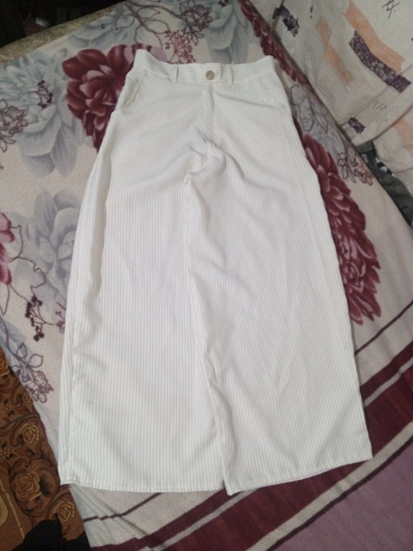 White pinstripe wide leg trousers with button closure (Category: Trousers) located in Baguio. Submitted by tyrontoler83676 (Listing ID 1466932902, Image 2). Description: ‎White Stripe baggy Pants ‎Length 40 inches ‎Waistline 30 inches ‎Leg opening 14 inches ‎Tight 15 inches - Color/Pattern: White with black vertical pinstripes - Fit: Wide leg, high waist style with belt loops and single front button closure - Pockets: Two practical side pockets -