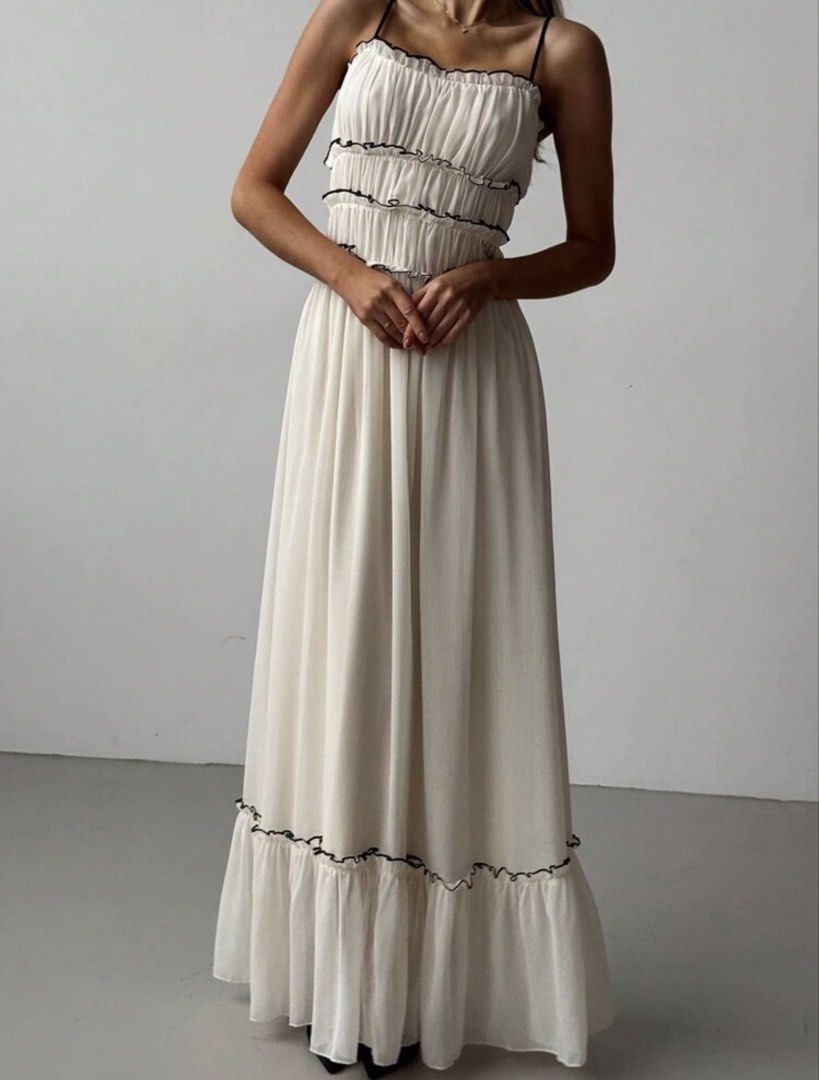 White Ruffle Long Maxi Dress Spaghetti Strap (Category: Dresses) located in Pasig City. Submitted by settey (Listing ID 1466878551, Image 2). Description: - Style: Long white maxi dress with delicate black-trimmed ruffles on the bodice and hem - Features: Thin spaghetti straps and a comfortable stretchy gathered bust - Material: Flowy, lightweight, and breezy chiffon-like fabric - Condition: Worn just once for a quick vacation and washed right af
