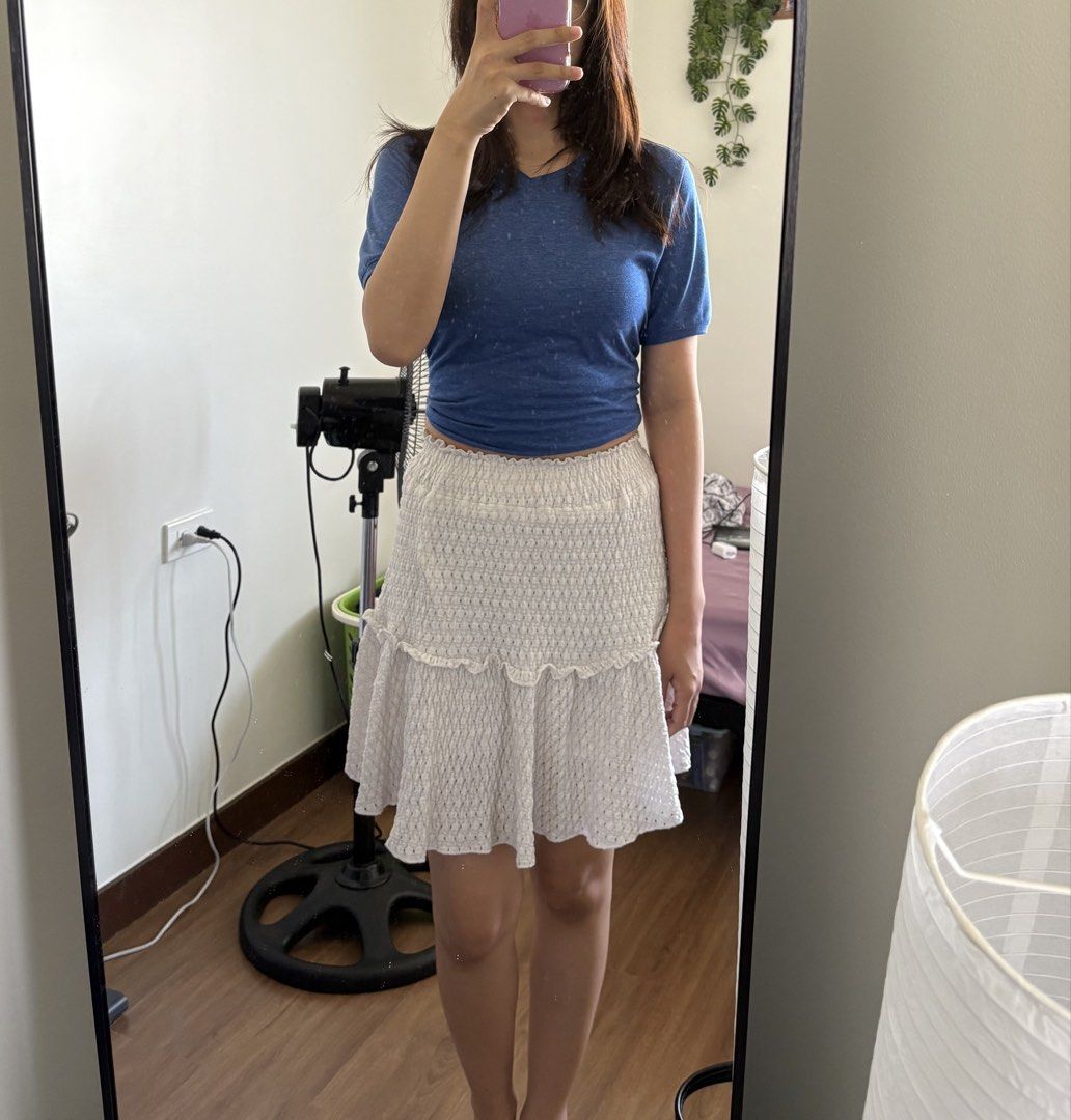 White Ruffle Smocked Mini Skirt (Category: Skirts) located in Pasay City. Submitted by polly.unpockets (Listing ID 1466799974, Image 1). Description: - Color: White - Style: Mini skirt with tiered ruffle hem - Waistband: Smocked and stretchy for extra comfort - Fabric: Lightweight with a subtle textured pattern - Length: Hits right above the knee - Condition: Clean and ready to wear.