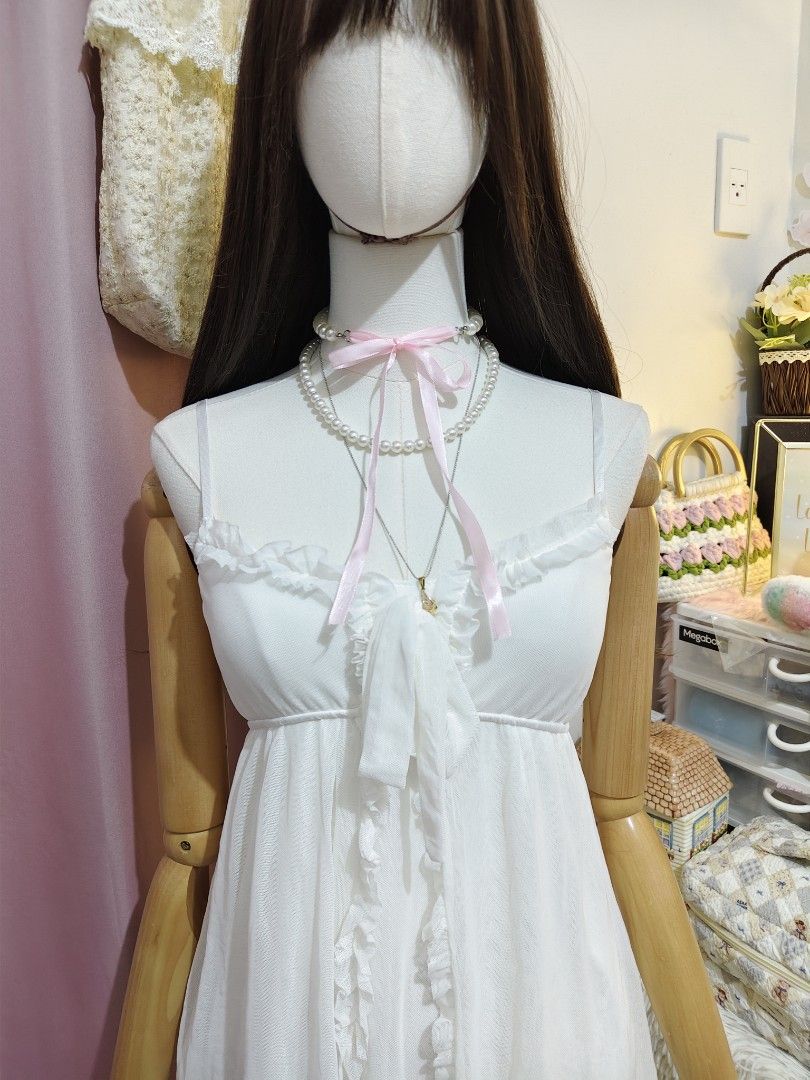White Ruffled Camisole Mini Dress (Category: Dresses) located in Manila. Submitted by chynii_28 (Listing ID 1466865508, Image 2). Description: - Size: XS to SM - Color: Clean white - Design: Sweet ruffle trim along neckline and front opening with a tie detail - Detail: Layered sheer mesh skirt overlay - Condition: Excellent, no flaws found.