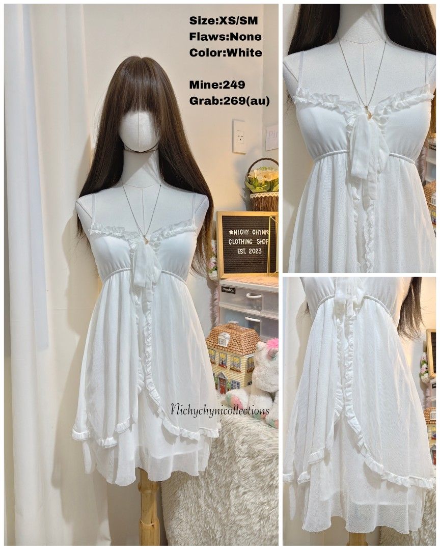 White Ruffled Camisole Mini Dress (Category: Dresses) located in Manila. Submitted by chynii_28 (Listing ID 1466865508, Image 1). Description: - Size: XS to SM - Color: Clean white - Design: Sweet ruffle trim along neckline and front opening with a tie detail - Detail: Layered sheer mesh skirt overlay - Condition: Excellent, no flaws found.
