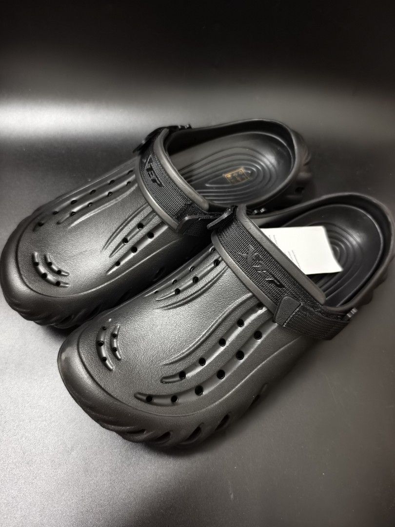 Xtep Black Clog Sandals Size 9 (Category: Flats & Sandals) located in Angeles City. Submitted by measaliman02351 (Listing ID 1466967766, Image 2). Description: - Brand: Xtep - Color: Black - Size: US 9 - Condition: Brand new with original tags attached - Design: Slip-on style with an adjustable top strap - Comfort: Lightweight foam construction with ventilation holes on the upper and sides - Traction: Wavy textured sole for a secure grip SIZE 43.