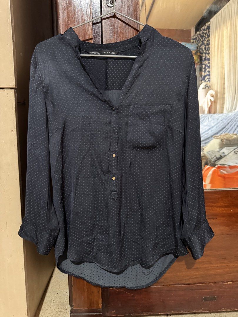 Zara Basic Dark Blue Polka Dot Blouse Size S (Category: Blouses) located in Marikina City. Submitted by 1stuffshop (Listing ID 1466791128, Image 1). Description: - Brand: Zara Basic - Size: Small (EUR, USA, MEX) - Color: Dark blue with subtle textured polka dots - Features: V-neck, partial front button placket, left chest pocket - Sleeves: Long sleeves with button cuffs - Hem: Curved hemline, slightly longer in the back.
