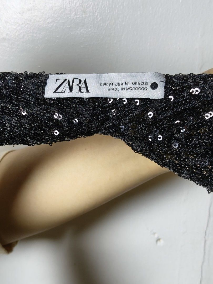 Zara Black Sequin Halter Top Size M (Category: Sleeveless) located in Manila. Submitted by ashie_clothing (Listing ID 1466964080, Image 3). Description: - Brand: Zara - Size: Medium (Made in Morocco) - Material & Design: Fully covered in shiny black sequins with a chic draped front and open back - Fit: Secure tie-around waist straps - Condition: Excellent, all sequins intact - Perfect for: Parties, clubbing, and nights out.