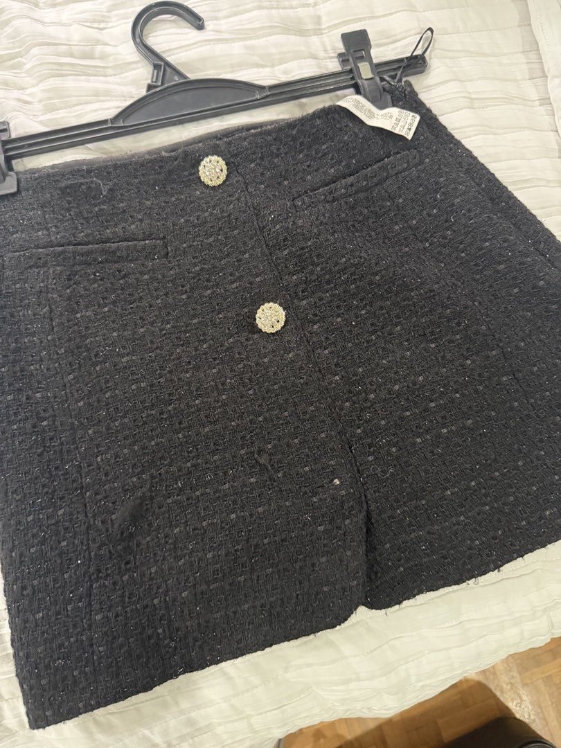 Zara Black Tweed Skort Size XS (Category: Skirts) located in Quezon City. Submitted by afternoonstore (Listing ID 1466842474, Image 1). Description: - Brand: Zara - Size: XS - Origin: Made in Turkey - Material/Design: Black textured tweed with subtle sparkle - Details: Two statement rhinestone buttons and faux front pockets - Comfort: Built-in shorts underneath - Style: Versatile classic for casual or dressed-up looks.