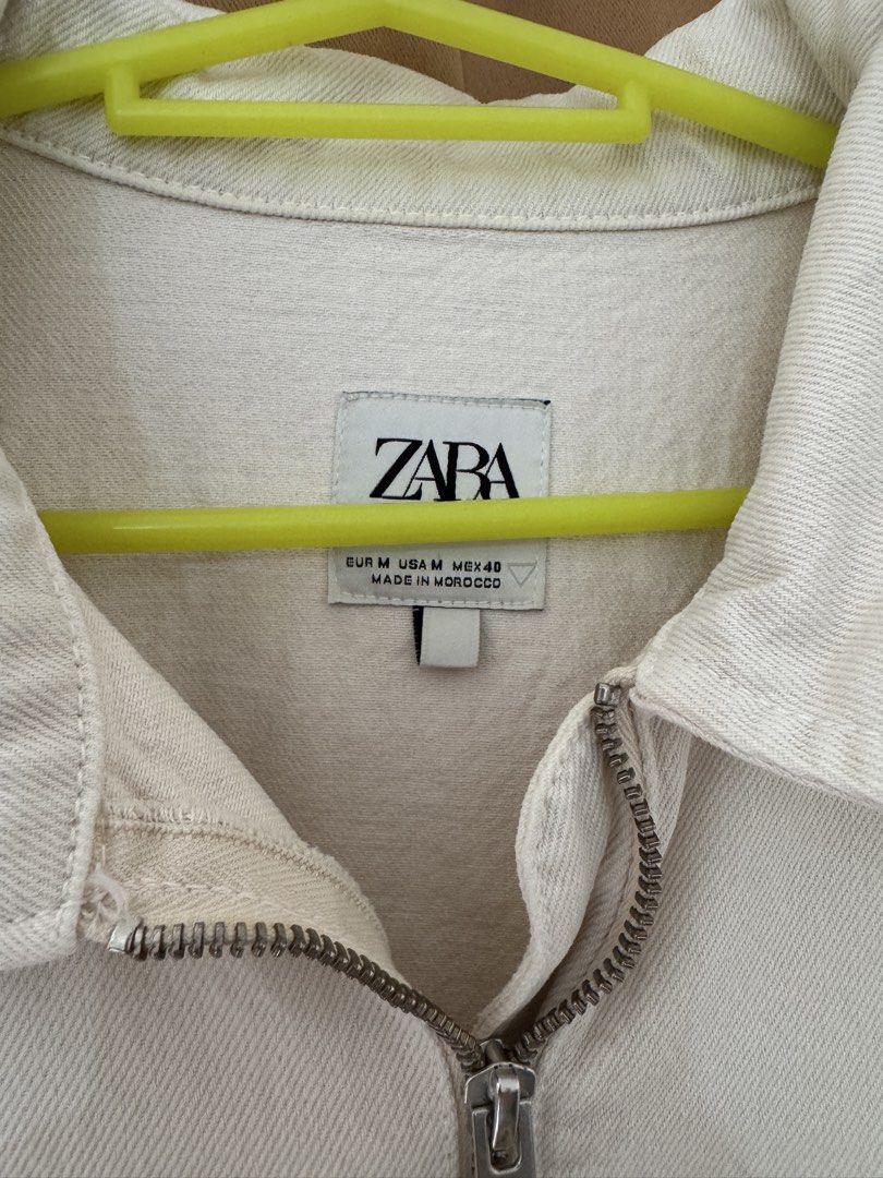 Zara Off-White Quarter Zip Denim Jacket Size M (Category: Coats, Jackets and Outerwear) located in Manila. Submitted by noblephoenix-8959 (Listing ID 1466819185, Image 2). Description: - Brand/Model: Zara Jacket - Size: Medium - Color: Off-white / Clean neutral tone - Material: Sturdy cotton denim (Made in Morocco) - Design: Quarter-zip front with collar and double chest pocket - Fit: Relaxed fit with elasticated hem and cuffs - Style: Perfect fo