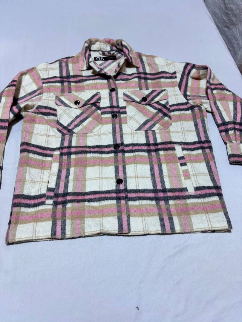 Zara Pink Plaid Oversized Overshirt Jacket (Category: Coats, Jackets and Outerwear) located in Pasig City. Submitted by heneralsupremo1892 (Listing ID 1466809006, Image 1). Description: Zara plaid overshirt in pink, white, and black tones. Button-down front closure with matching buttons on cuffs and dual chest flap pockets. Two side welt pockets included. Classic collar and structured fit. Wool-blend material texture visible throughout. Great lay