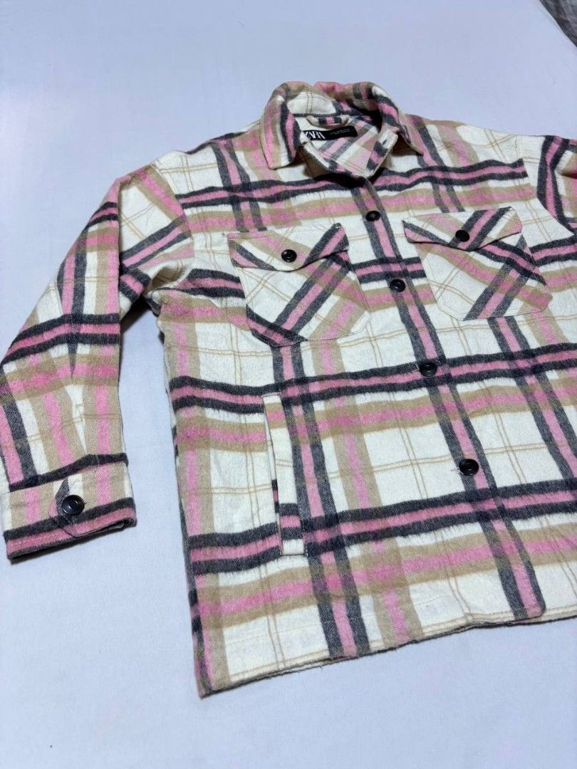 Zara Pink Plaid Oversized Overshirt Jacket (Category: Coats, Jackets and Outerwear) located in Pasig City. Submitted by heneralsupremo1892 (Listing ID 1466809006, Image 3). Description: Zara plaid overshirt in pink, white, and black tones. Button-down front closure with matching buttons on cuffs and dual chest flap pockets. Two side welt pockets included. Classic collar and structured fit. Wool-blend material texture visible throughout. Great lay