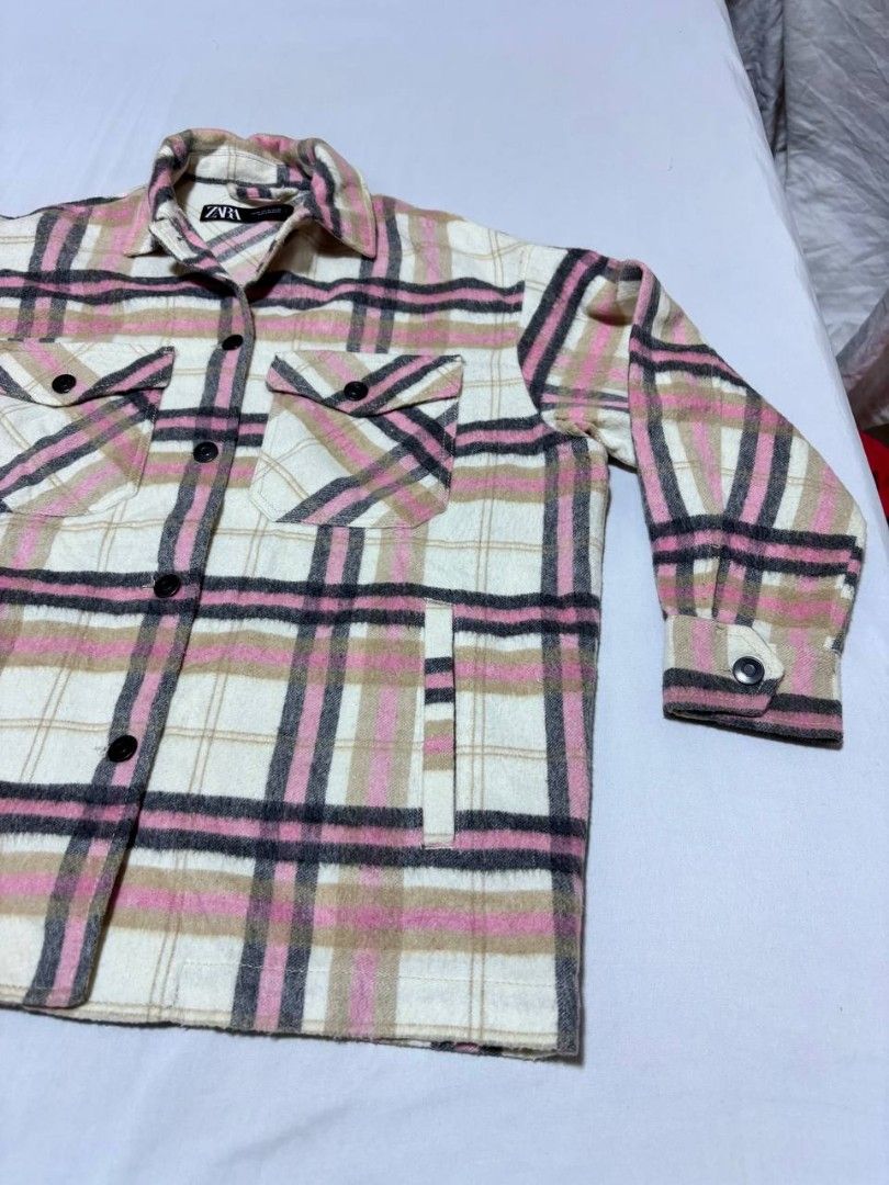Zara Pink Plaid Oversized Overshirt Jacket (Category: Coats, Jackets and Outerwear) located in Pasig City. Submitted by heneralsupremo1892 (Listing ID 1466809006, Image 2). Description: Zara plaid overshirt in pink, white, and black tones. Button-down front closure with matching buttons on cuffs and dual chest flap pockets. Two side welt pockets included. Classic collar and structured fit. Wool-blend material texture visible throughout. Great lay