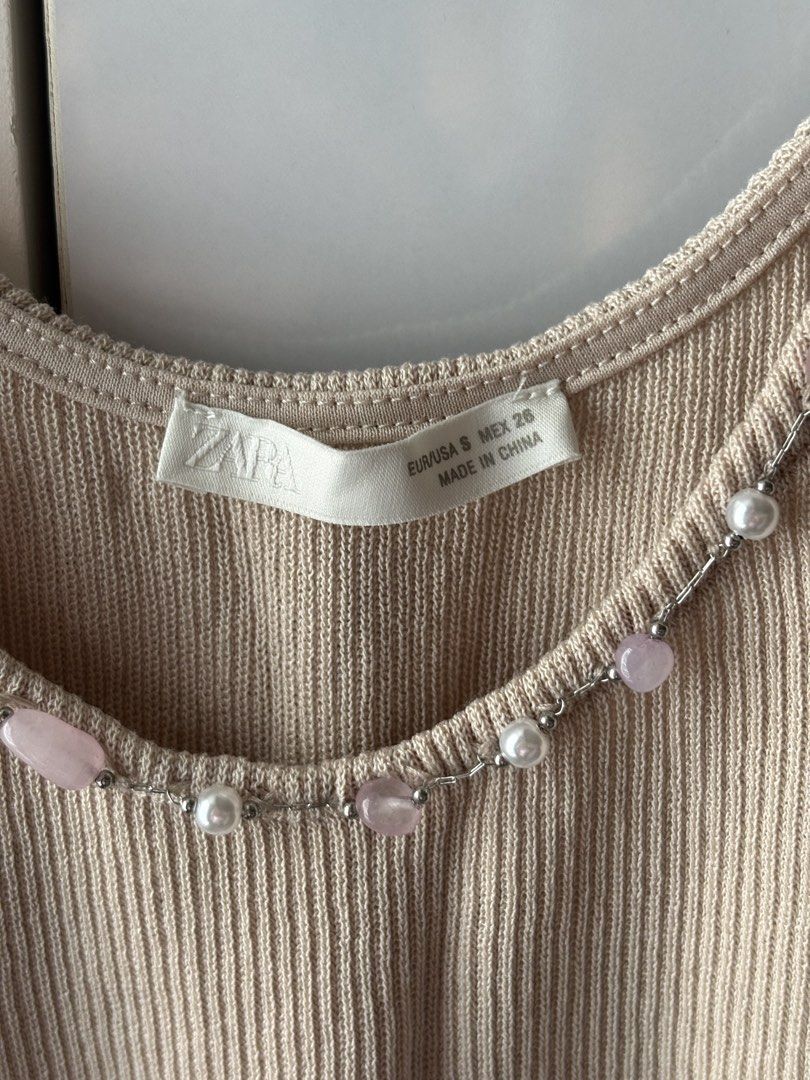 Zara Ribbed Beaded Top (Category: Sleeveless) located in Manila. Submitted by jodi.declutters (Listing ID 1466784191, Image 3). Description: - Brand: Zara - Never Used - SRP 1795 - Style: Ribbed knit tank top - Color: Beige - Size: S (fits true to size) - Details: Beaded straps with faux pearls and pink stones - Fabric: Lightweight and stretchy - Condition: Worn just a couple of times, still in great shape.