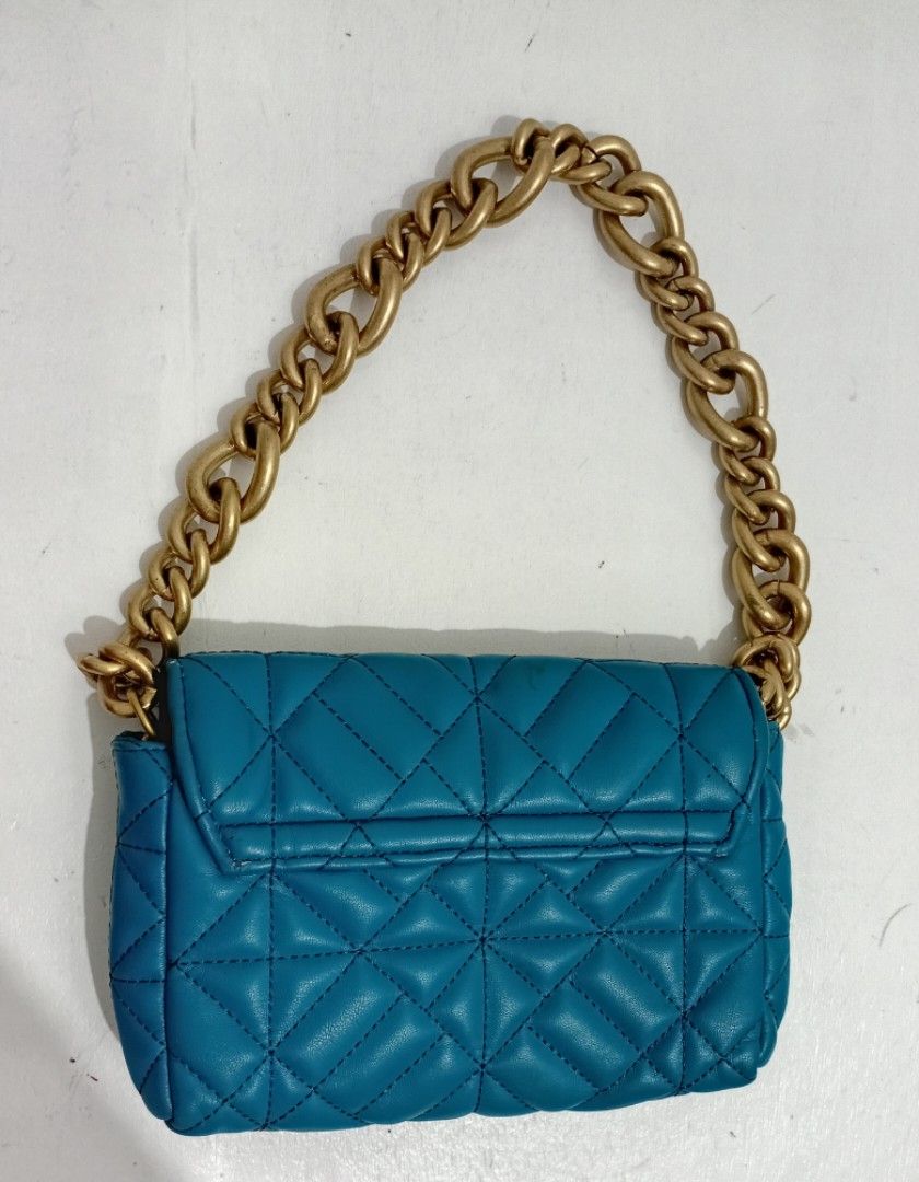 Zara Teal Shoulder bag (Category: Shoulder Bags) located in Navotas City. Submitted by riyuwi (Listing ID 1466885696, Image 1). Description: PreOwned Lightly uSed WellUsed ZARA Bright teal Quilted Shoulder bag - Design: Quilted pattern with thick chunky gold chain strap - Closure: Magnetic snap on front flap - Interior: Dark fabric lining with a small tag inside the pocket - Size: Small . Compact, perfect for daily essentials - Condition: Clean i