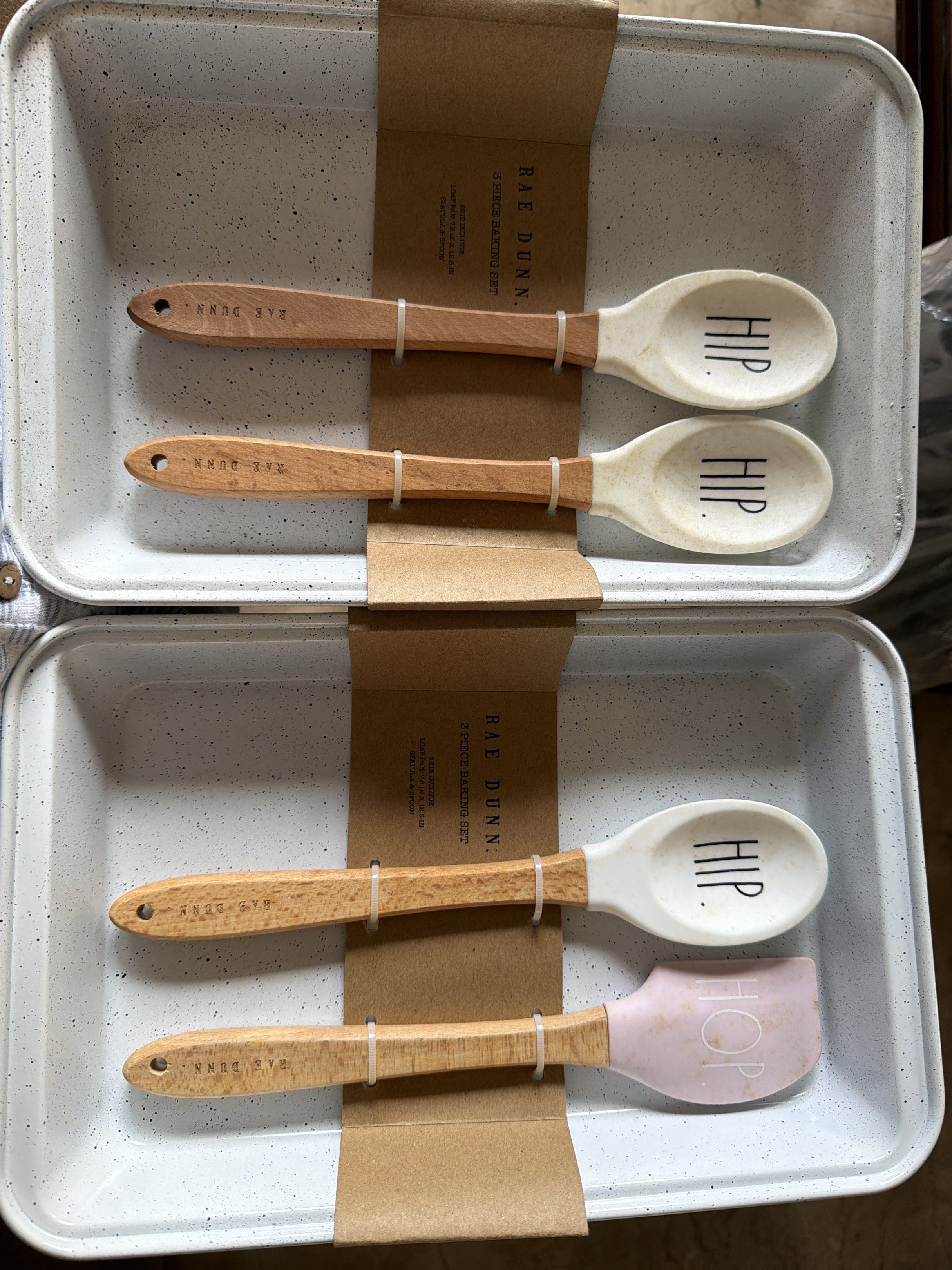 2 set Rae Dunn 3-Piece Kitchen Utensil Set (Category: Other Kitchenware & Tableware) located in Manila. Submitted by yournextshop (Listing ID 1419040510, Image 1). Description: - Rae Dunn 3-piece utensil set - Includes: 2 spoons (HIP), 1 spatula (HOP) - Features: Wooden handles, silicone heads (white or pink) - Comes with a white speckled baking dish.
