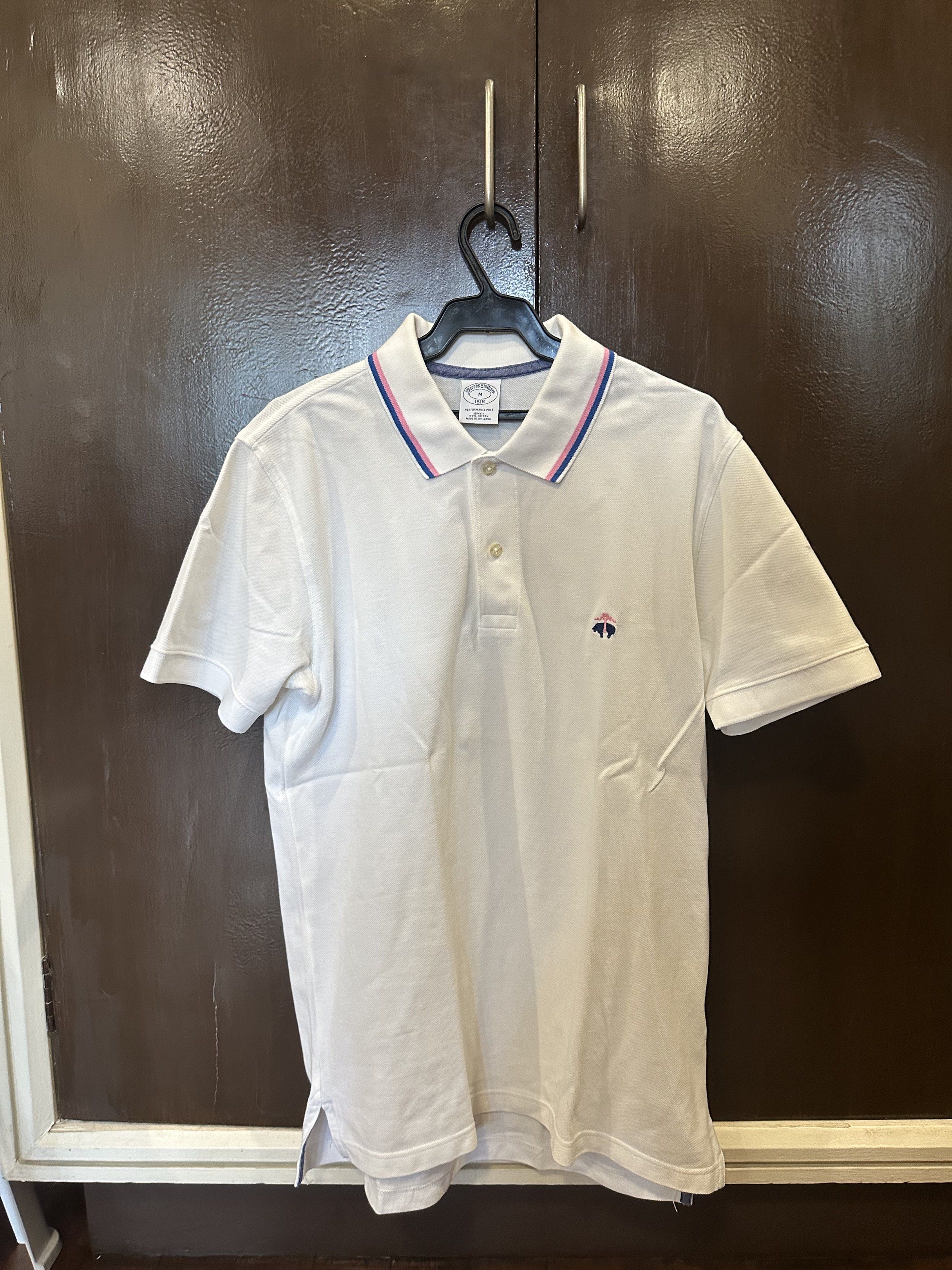 Brooks Brothers Performance Polo Shirt - M (Category: Tshirts & Polo Shirts ) located in Paranaque City. Submitted by mrbentables (Listing ID 1419071223, Image 1). Description: - Brooks Brothers Performance Polo Shirt - Size: M - Fit: Slim - Material: 100% Cotton - Collar: Striped (Blue & Pink) - Features the Brooks Brothers logo on the chest.