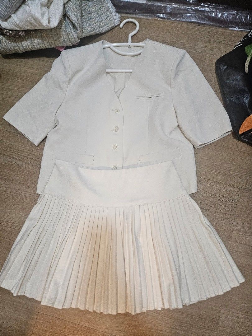 Cream Pleated Skirt Suit (Category: Skirts) located in Angeles City. Submitted by ssomma (Listing ID 1419111771, Image 2). Description: - Cream-colored skirt suit - Includes a jacket and a skirt - Jacket features: - Button-up closure - Pockets - Short sleeves - Skirt is pleated - Made of lightweight fabric.