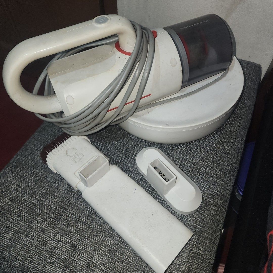 DEERMA CM1300 Handheld Vacuum Cleaner (Category: Vacuum Cleaner & Housekeeping) located in Malabon City. Submitted by grfpx (Listing ID 1418987013, Image 1). Description: Compact white handheld vacuum cleaner with red accent. Includes charging base and brush attachment. Easy to maneuver. *UV Working **Filter needs replacement.