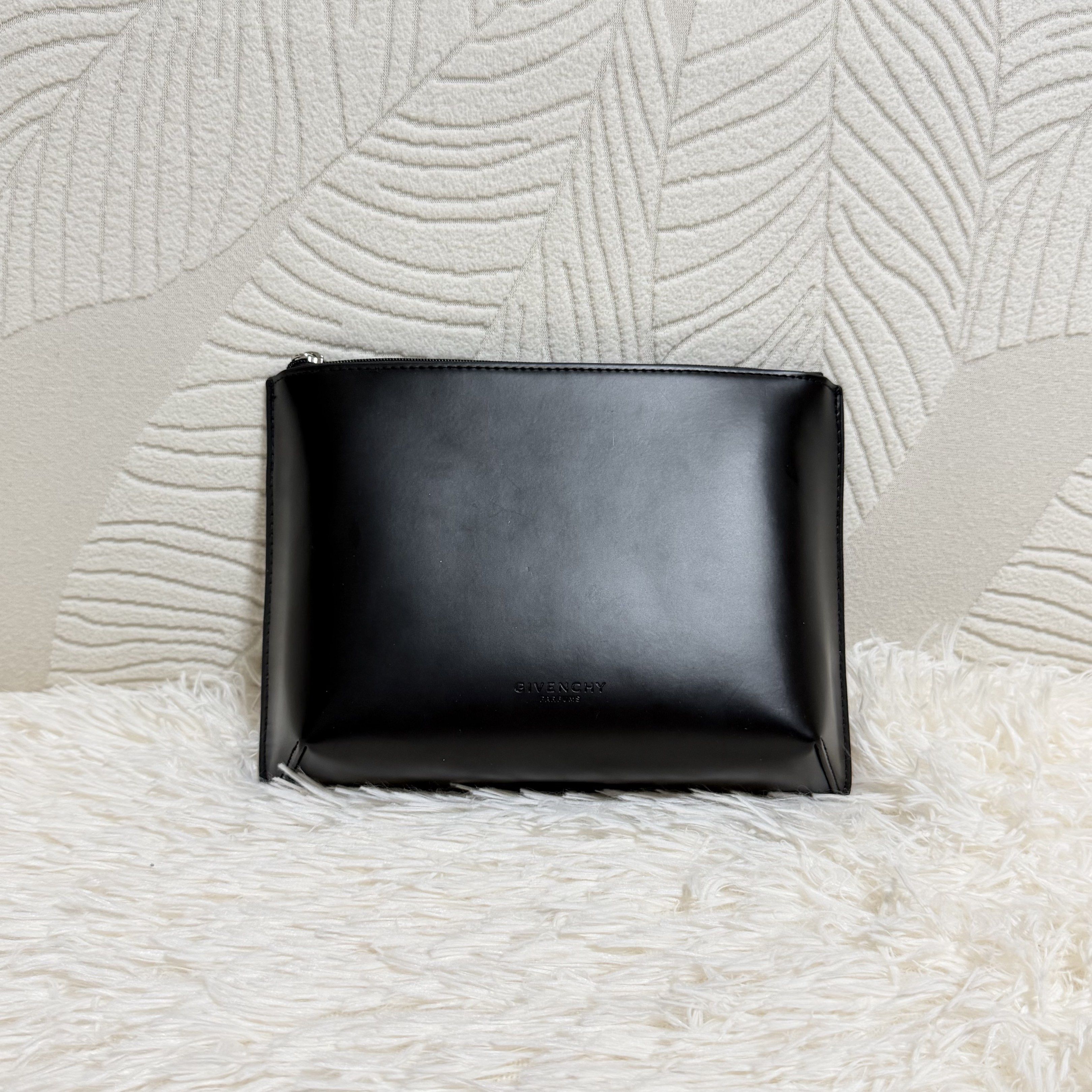 Givenchy Novelty pouch (Category: Luxury Bags & Wallets) located in Pasig City. Submitted by trendapparelph (Listing ID 1418992637, Image 1). Description: - Givenchy Novelty Pouch - Classic black color - Features the Givenchy logo - Stylish and versatile design - Interior lining with a unique pattern.