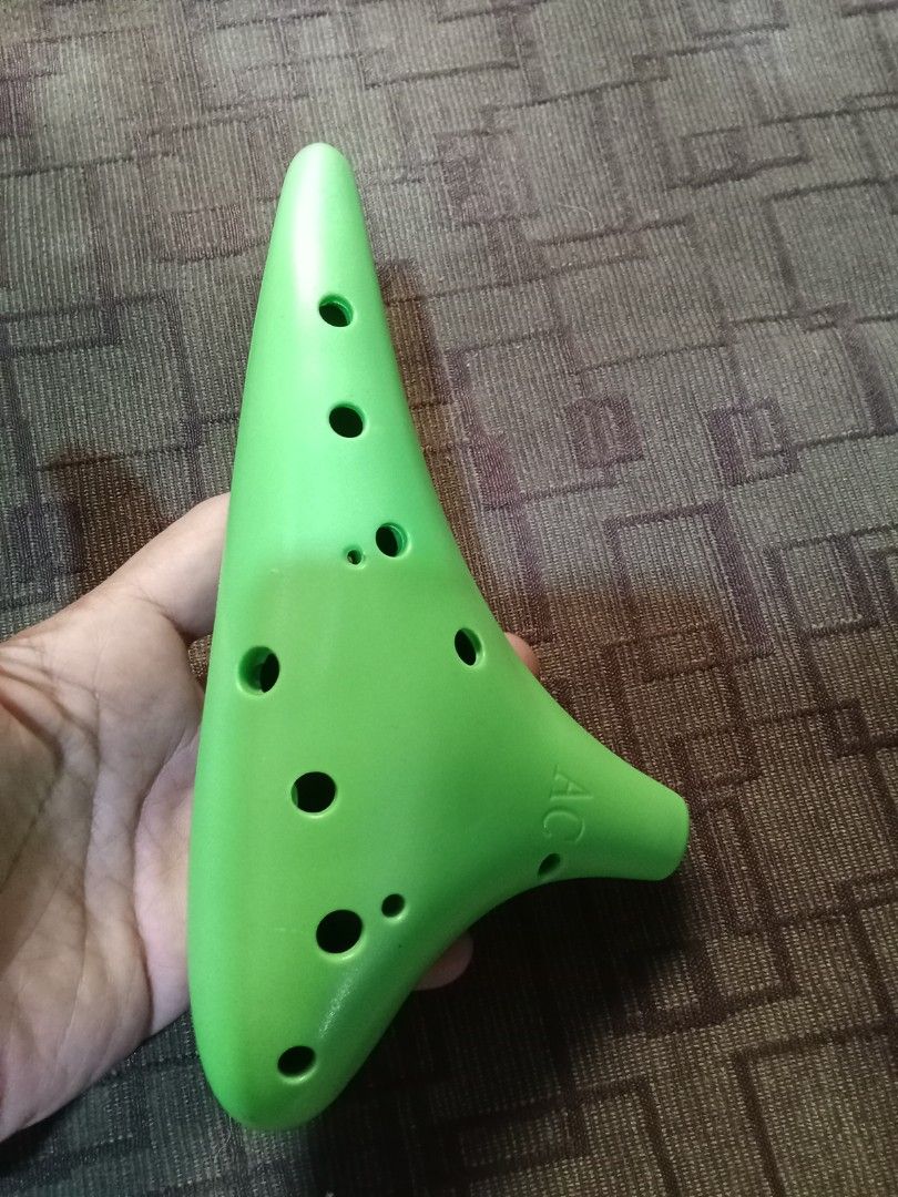 Green Ocarina (Category: Musical Instruments) located in Bocaue. Submitted by marajapansurplus (Listing ID 1418996983, Image 1). Description: - Green ocarina - Features multiple holes and a mouthpiece - Marked with "AC" - Musical instrument - Easy to play.