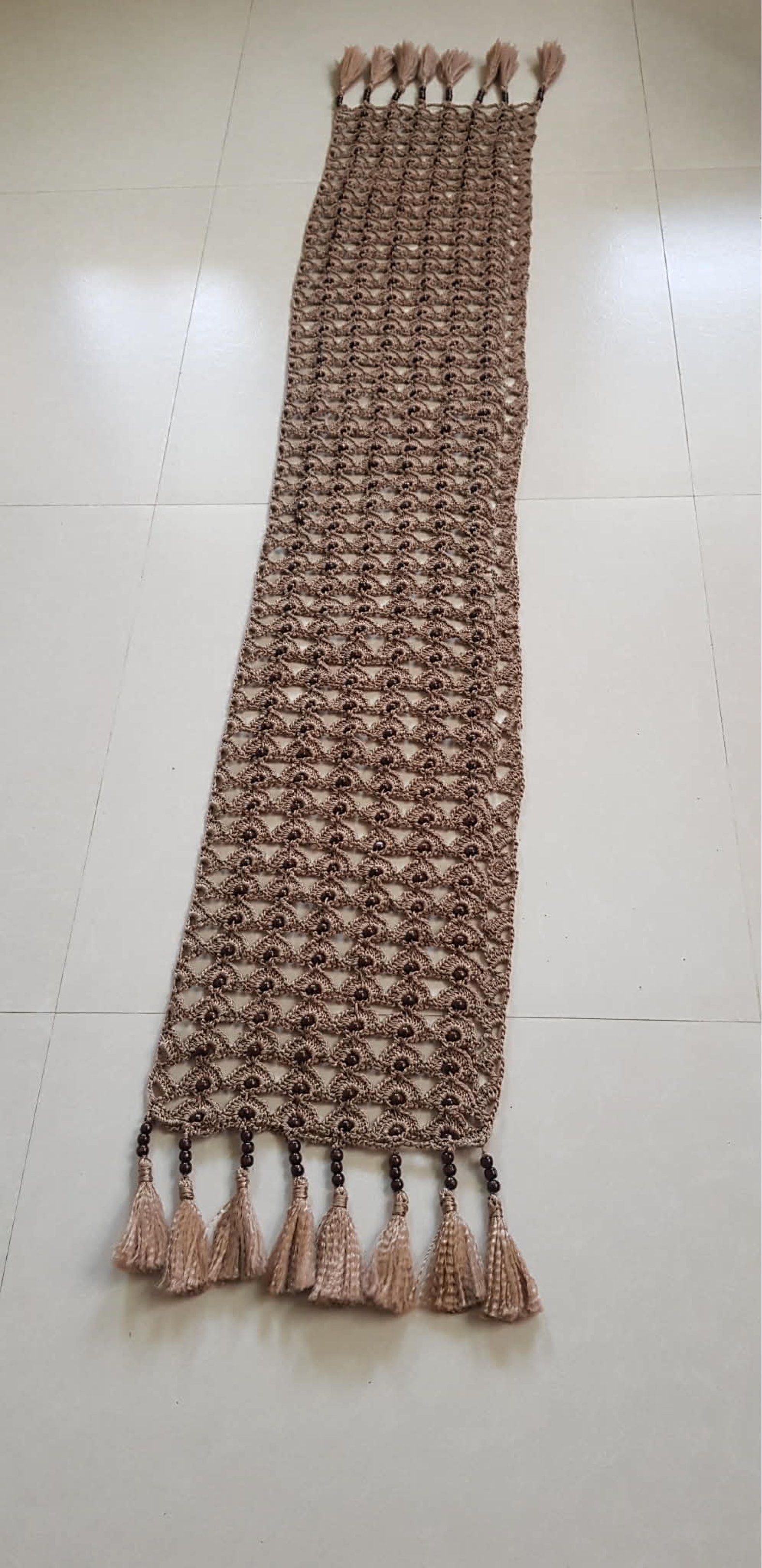 Handmade Crochet Table Runner with Tassels (Category: Table Linen & Textiles) located in Manila. Submitted by er3h24 (Listing ID 1419112833, Image 2). Description: - Handmade crochet table runner - Features an open weave design - Includes decorative tassels - Neutral brown color - Adds elegance and warmth - Suitable for various table settings - Perfect for special occasions or everyday use FOR PRE ORDER.