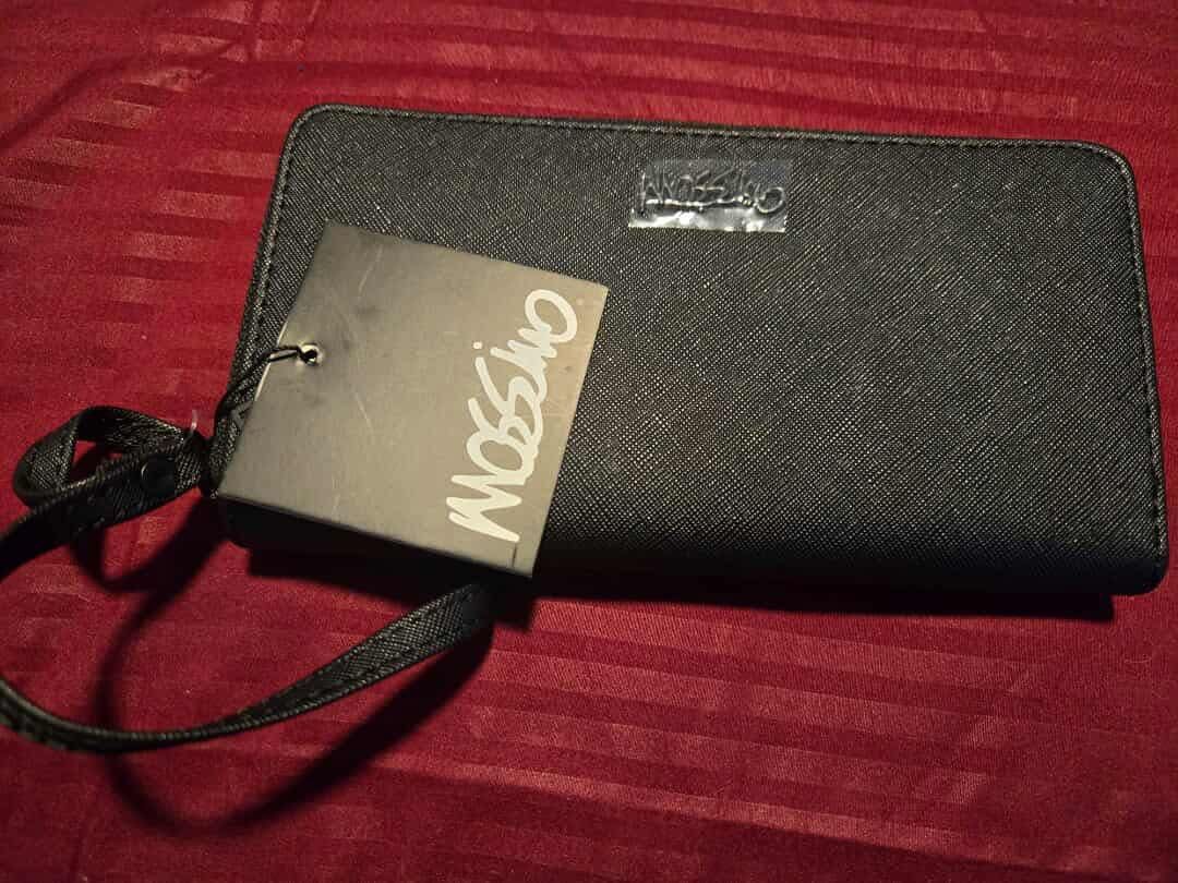Mossimo Black Wallet (Category: Wallets & Card holders) located in Manila. Submitted by corryyy (Listing ID 1419117888, Image 1). Description: - Black Mossimo wallet - Features a wrist strap - Zip-around style - Textured surface - Metal Mossimo logo - Includes a tag.