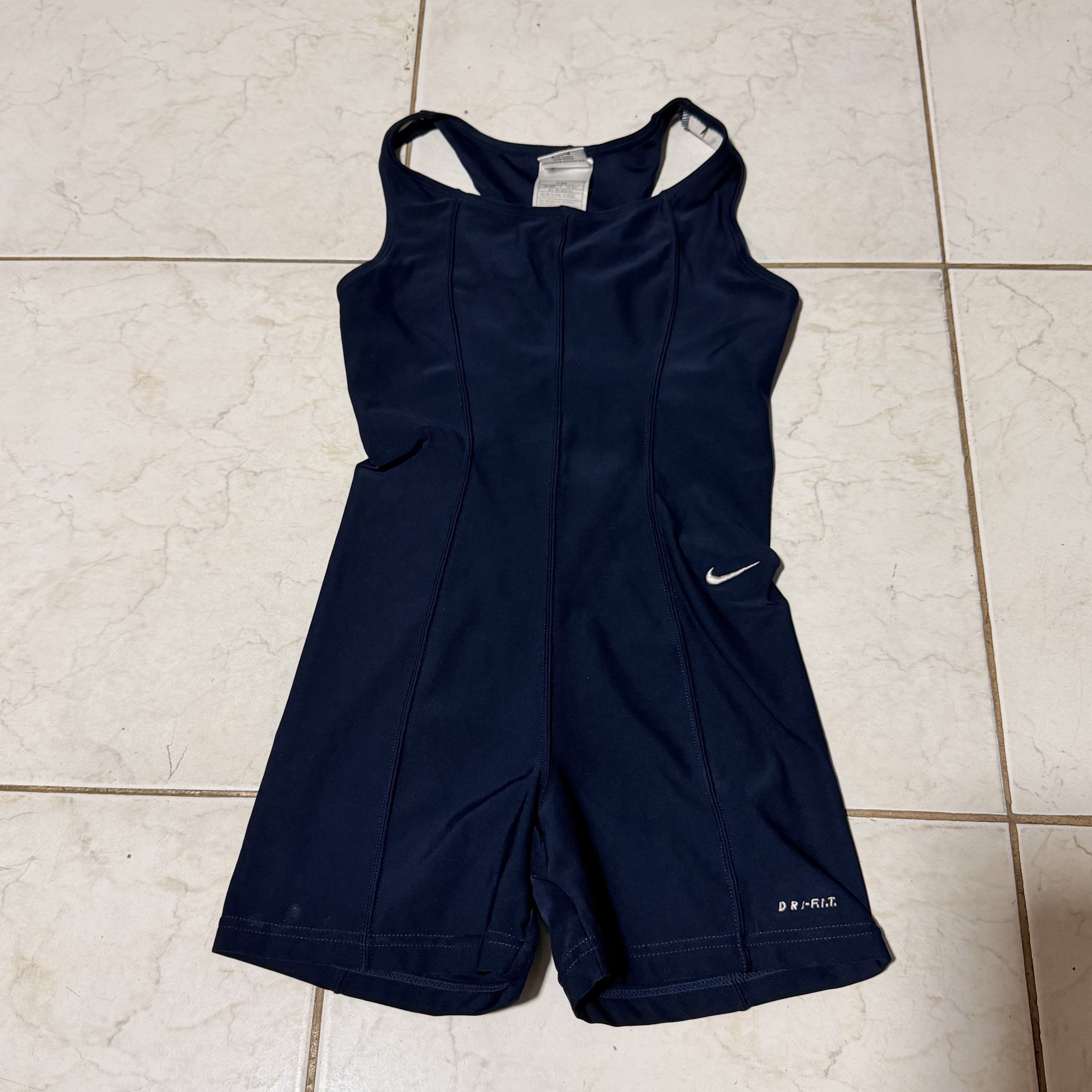 Nike Dri-FIT Athletic Romper Swimsuit (Category: Activewear) located in Pasig City. Submitted by decluttertrends (Listing ID 1418999748, Image 1). Description: - Navy blue Nike athletic romper swimsuit - Racerback design - Dri-FIT technology - Nike logo on chest - One-piece design with shorts - Size M but fits xs to semi med - Made in Taiwan.