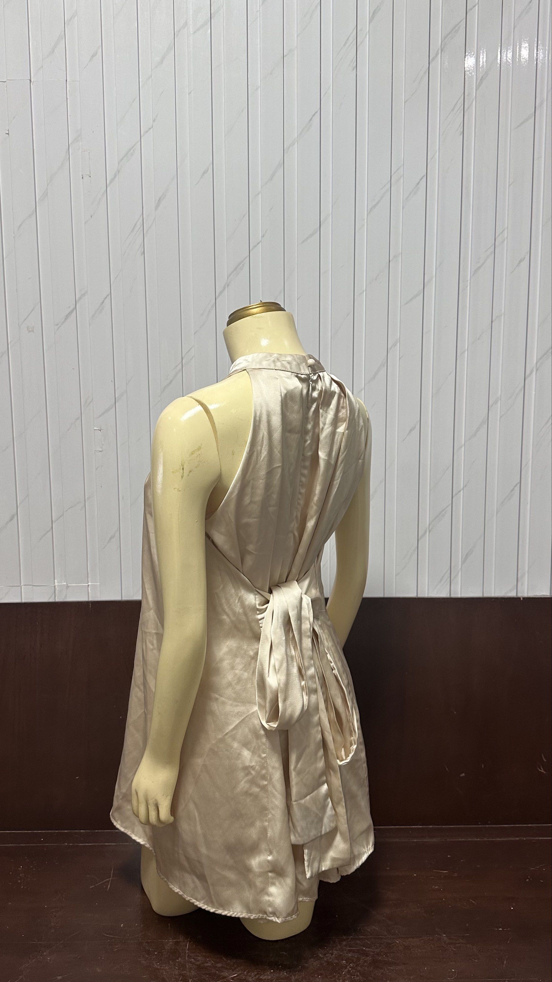 Satin Halter Dress (Category: Dresses) located in Taguig. Submitted by ylluhhhh (Listing ID 1419192039, Image 2). Description: Elegant satin halter dress in a neutral champagne color. Features a high neckline and a flattering A-line silhouette. The back has a tie detail for an adjustable fit. Perfect for special occasions or a night out. The dress is sleeveless and falls to about knee length..