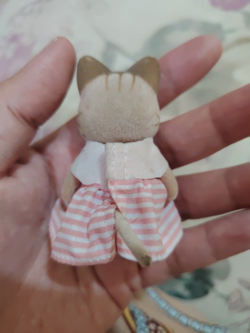 Sylvanian Families Cat Figure (Category: Figurines & Statues) located in Iligan City. Submitted by shehabdor98515 (Listing ID 1419188358, Image 2). Description: - Sylvanian Families cat figure - Wearing a cute pink and white striped dress - Features a white collar with a pearl-like button - Light brown body and brown ears - Small size, ideal for play or collecting.